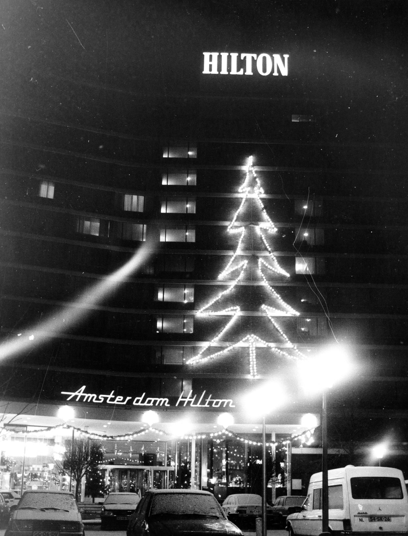 Kerstboom van lampjes tegen de gevel van het Amsterdam Hilton