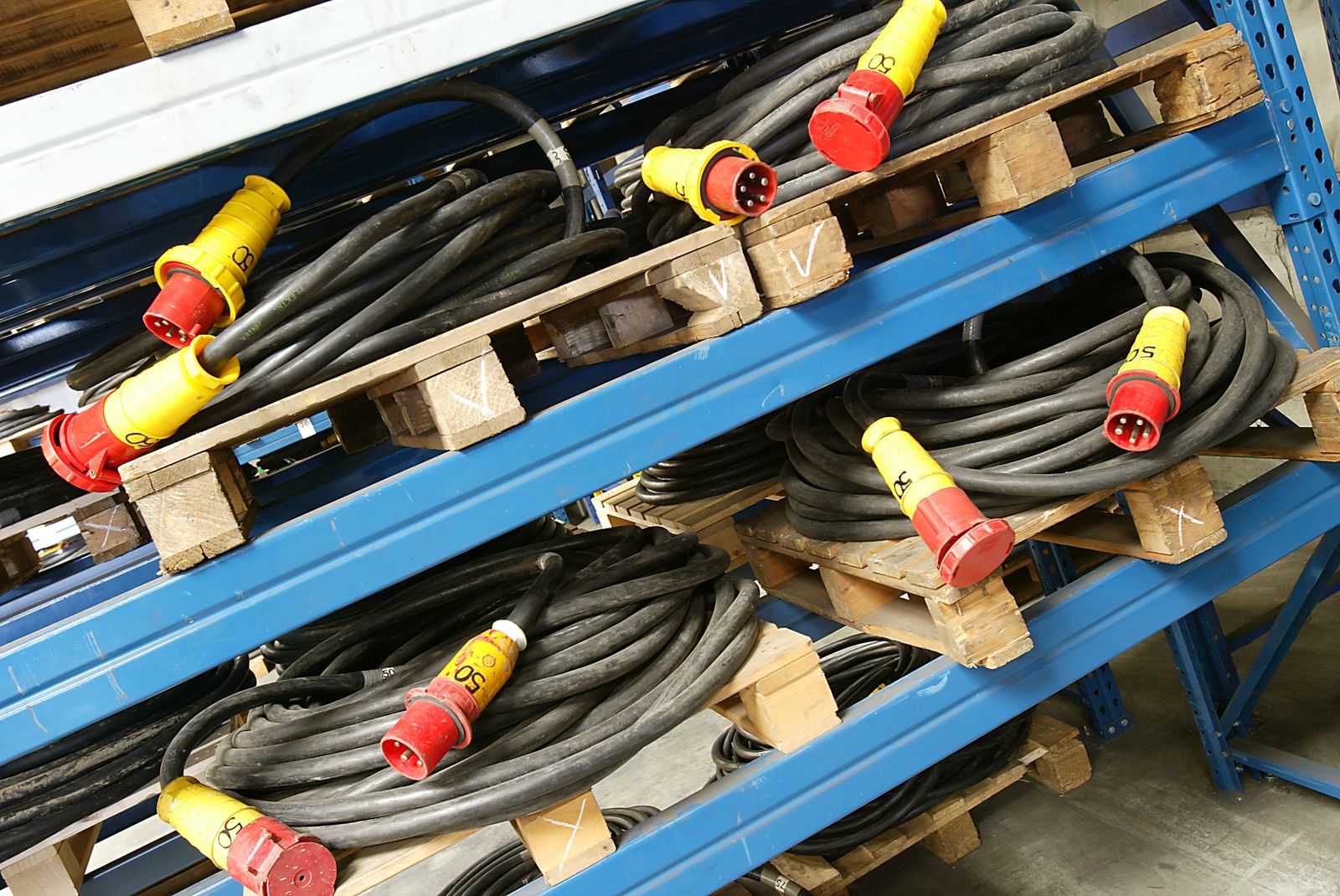 Homan huurkabels met krachtstroomstekkers op pallets in het magazijn